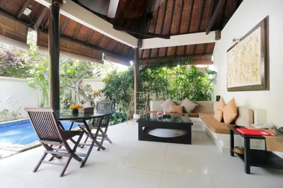 a living room with a table and a couch at Heliconia Villa in Seminyak