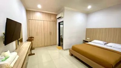 a bedroom with a bed and a flat screen tv at Simpang Inn Hotel in Legian