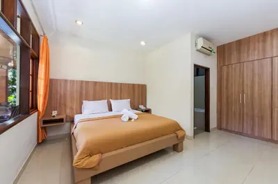 a bedroom with a bed with a stuffed animal on it at Simpang Inn Hotel in Legian
