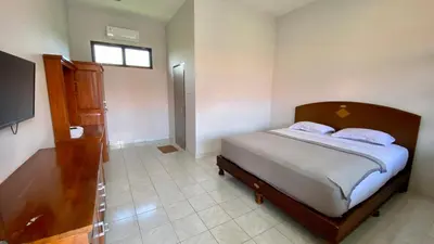 a bedroom with a bed and a television in it at Simpang Inn Hotel in Legian