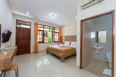 a bedroom with a bed and a sink and a toilet at Simpang Inn Hotel in Legian