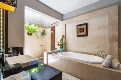 a bathroom with a large tub and a sink at The Akasha Seminyak Bali Luxury Villas in Seminyak