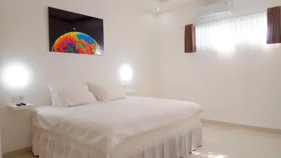 a bedroom with a bed with a painting on the wall at The Bali Bubble in Sanur
