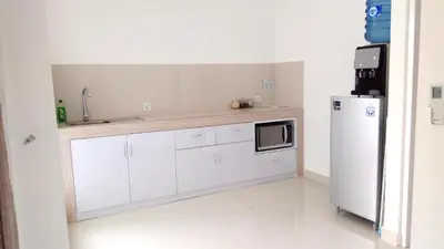 a kitchen with white cabinets and a white refrigerator at The Bali Bubble in Sanur