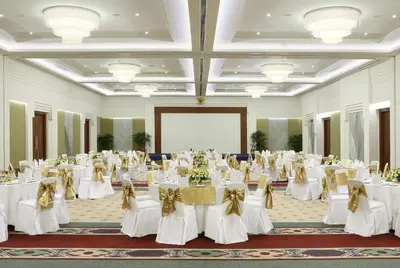 a banquet hall with white tables and chairs at Bintang Bali Resort in Kuta