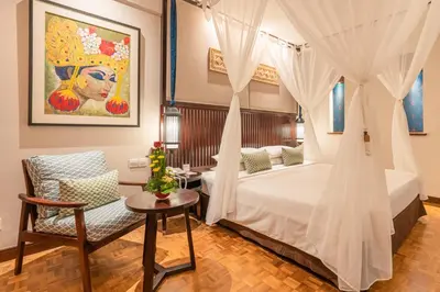 a bedroom with a bed and a table and a chair at Bintang Bali Resort in Kuta