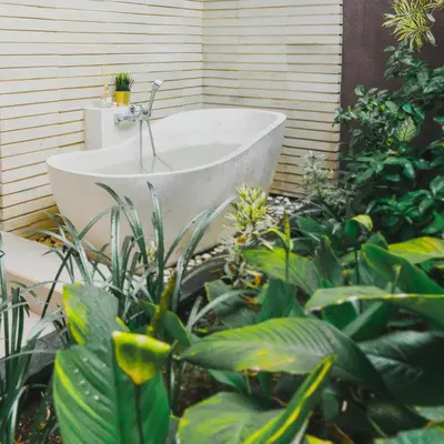 a white bath tub in a garden with plants at Villa Lapiz Lazuli Seminyak Kuta in Seminyak