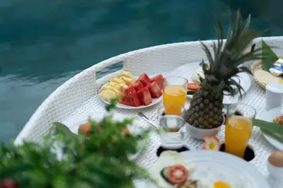 a table with breakfast foods and drinks on it at Villa Lapiz Lazuli Seminyak Kuta in Seminyak