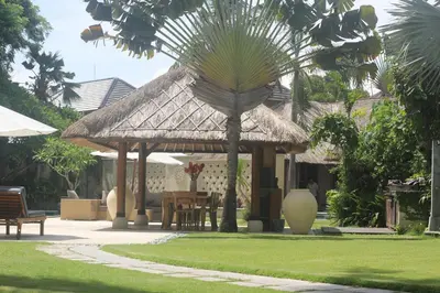 a pavilion with a table and a palm tree at Sienna Villas Seminyak in Seminyak