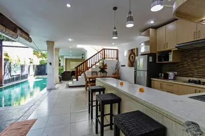 a kitchen with a bar and a swimming pool at Villa Mienna in Seminyak