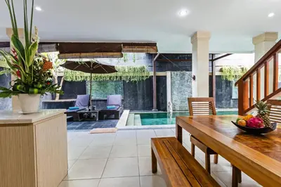 a dining room with a table and a pool at Villa Mienna in Seminyak