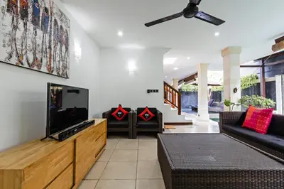 a living room with a flat screen tv and couches at Villa Mienna in Seminyak