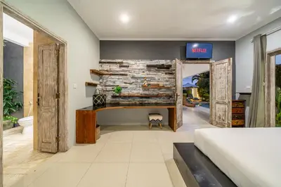 a bedroom with a bed and a tv on the wall at Villa Sarong 1 in Seminyak