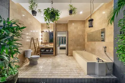 a bathroom with a tub and a toilet and plants at Villa Sarong 1 in Seminyak