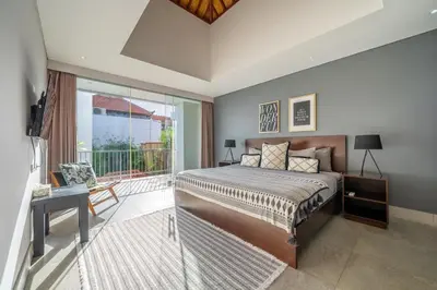 a bedroom with a bed and a balcony at Villa Jekumah in Seminyak