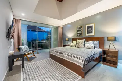 a bedroom with a bed and a balcony at Villa Jekumah in Seminyak
