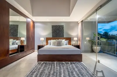 a bedroom with a large bed and a balcony at Villa Jekumah in Seminyak