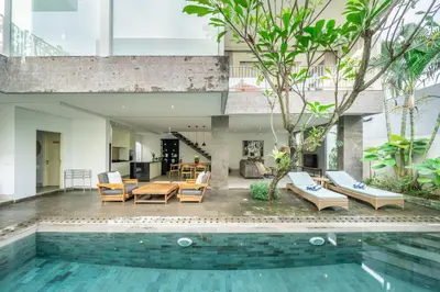 a house with a swimming pool and a living room at Villa Jekumah in Seminyak