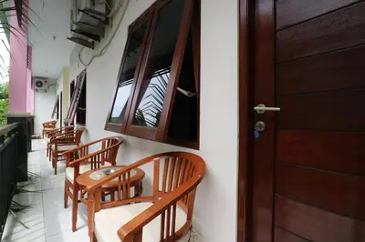 a row of wooden chairs sitting next to a door at Anantaya Home Denpasar in Denpasar