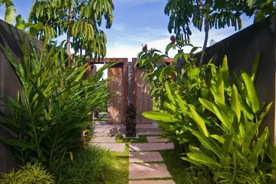 a garden with a fence and some plants at Komea Villa in Canggu