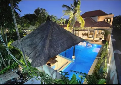 a large umbrella in front of a swimming pool at Villa Seminyak William in Seminyak