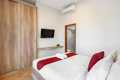 a bedroom with a bed and a tv on the wall at Cove Villa Prana in Jimbaran