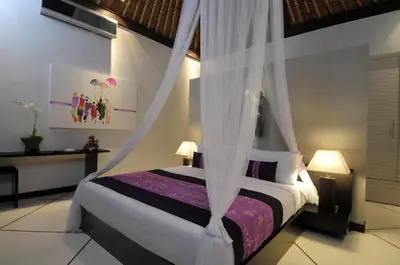 a bedroom with a bed with a mosquito net at Villa Maju in Seminyak