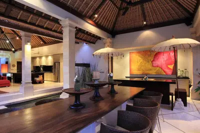 a dining room with a table and chairs in a room at Villa Maju in Seminyak