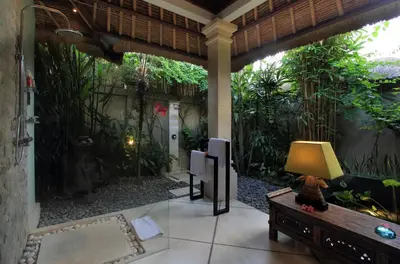 a patio with a fish tank and a tv at Villa Maju in Seminyak