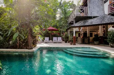 a swimming pool in front of a house at Villa Hangat in Seminyak