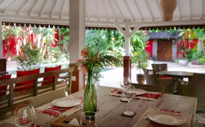 a wooden table with a vase with flowers on it at Villa Hangat in Seminyak
