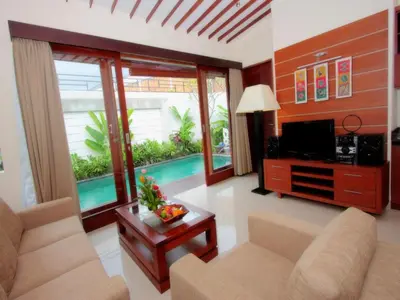 a living room with a tv and a couch and a table at Grania Bali Villas in Seminyak