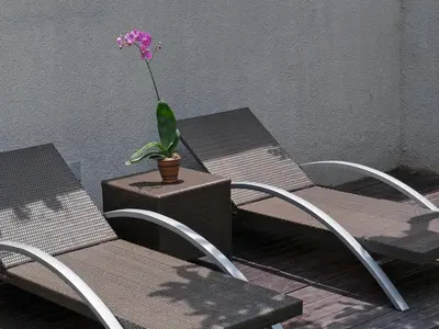 two chairs and a flower in a pot on a table at Grania Bali Villas in Seminyak