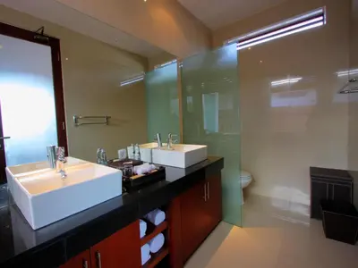 a bathroom with two sinks and a large mirror at Grania Bali Villas in Seminyak