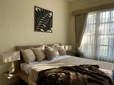 a bedroom with a large bed and a window at Artemis Villa Hotel in Seminyak
