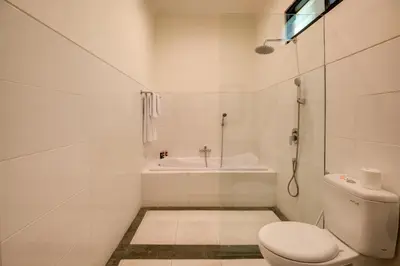 a white bathroom with a toilet and a sink at Gracia Bali Villas & Apartment Managed by Manara in Seminyak