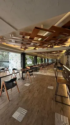 a room with tables and chairs in a building at Bloo Bali Hotel in Legian