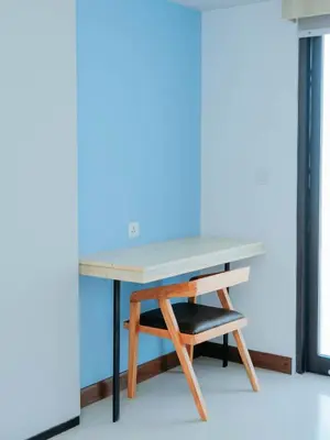 a desk with a chair and a blue wall at Bloo Bali Hotel in Legian