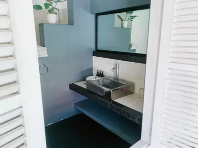 a bathroom with a sink and a mirror at Casa Artista By Kresna Hospitality in Seminyak