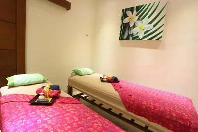 two beds in a room with pink covers on them at The Jas Villas in Seminyak