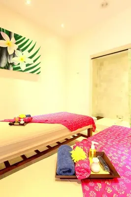 a bedroom with two beds and a tray with towels at The Jas Villas in Seminyak