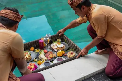 a group of people standing around a table with food at Villa Maviba in Seminyak