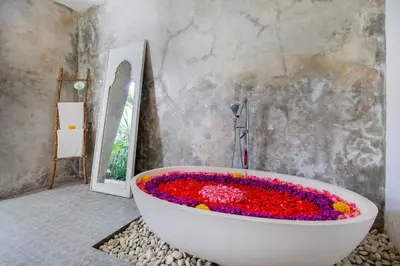 a bath tub filled with flowers in a bathroom at Villa Maviba in Seminyak