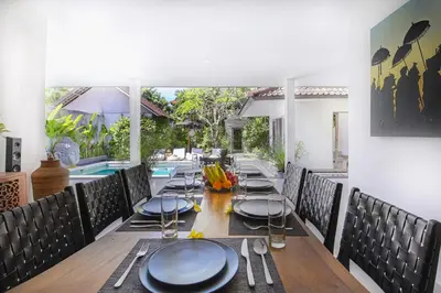 a dining room with a table and a pool at Villa Maviba in Seminyak