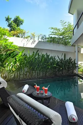 a resort with a pool and a table with drinks on it at Villa La Sirena by Nagisa Bali in Seminyak