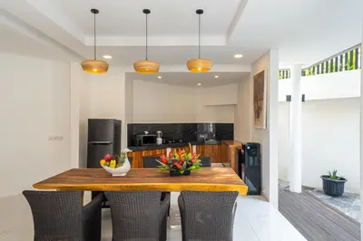 a kitchen with a wooden table and chairs at Villa La Sirena by Nagisa Bali in Seminyak