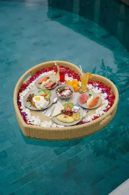 a tray of food on a table in a swimming pool at Villa La Sirena by Nagisa Bali in Seminyak
