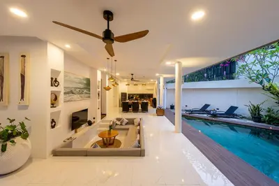 a living room with a pool and a ceiling fan at Villa La Sirena by Nagisa Bali in Seminyak