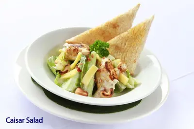a plate of food with a salad and tortilla chips at The Lokha Legian Resort & Spa in Legian