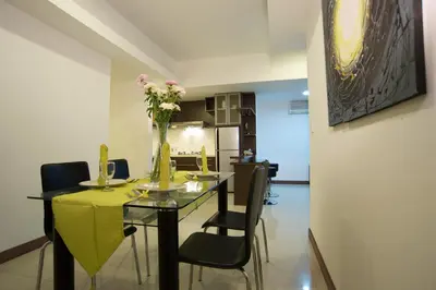 a dining room with a table with chairs and flowers on it at Sunset Residence and Condotel in Legian